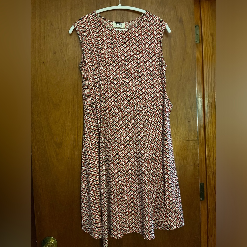 Jersey dress with crossover side tie belt and a flared skirt.